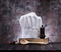 Cook hat, wooden spoons, spices and vegetables on a wooden table. Royalty Free Stock Photo